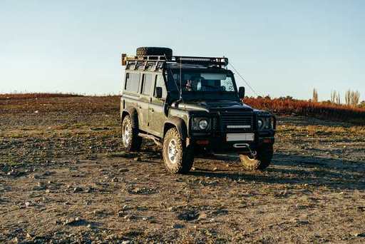 green-massive-off-road-car-parked-in-meadow-2023-1